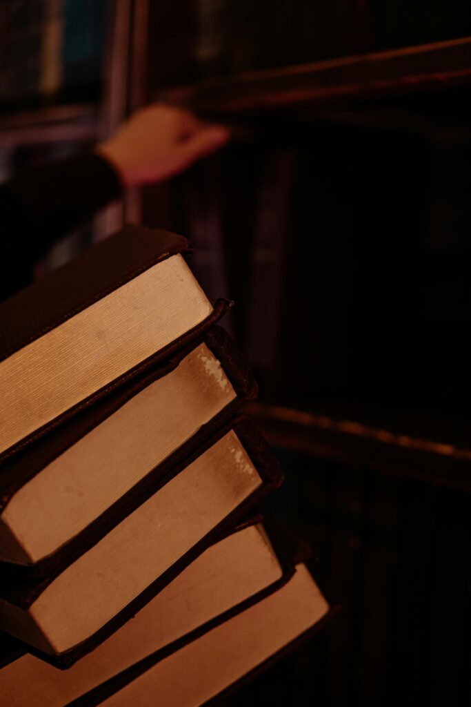 Atmospheric shot of books stacked in a dark library setting, evoking a magical and mysterious mood.